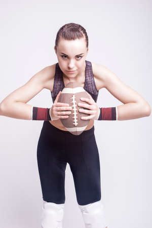 Sport Concept: Sportive Caucasian Female American Football Player with Ball. Vertical Imageの写真素材
