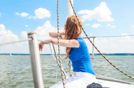 Portrait of Young Caucasian Woman Travelling Under Sail on Water. Horizontal Image Orientationの写真素材