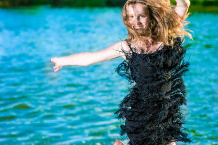 Lifestyle Concept: Portrait of Happy Smiling Woman Making a High Jump Near water Shore.Horizontal Image Orientationの写真素材