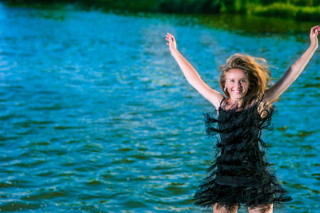 Lifestyle Concept: Portrait of Happy Smiling Woman Making a High Jump Near water Shore.Horizontal...