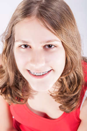 Medicine and Dental Concepts and Ideas. Smiling Teenager Girl Teeth Brackets. Against White Bckground. Vertical Image Orientationの写真素材