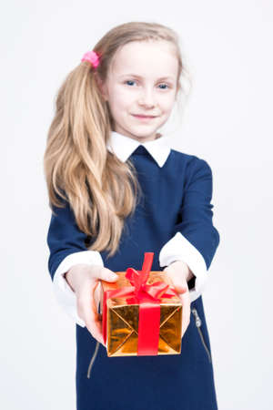 Portrait of cute Caucasian Blond Kid with Gift. Against White Background. Vertical Image Compositionの写真素材