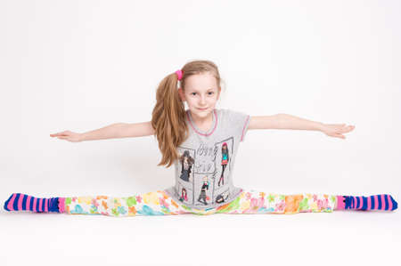 Happy and Cheerful Caucasuan Blond Girl Stretching and Doing the Splits. Positive Facial Expression. Horizontal Image Orientationの写真素材
