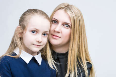 Family Values. Portrait of Mother and Daughter Sitting Together Embraced. Against White Background. Horizontal Imageの写真素材