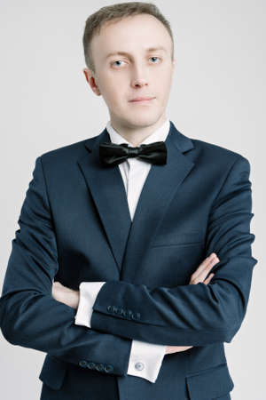 Portrait of Caucasian Handsome Man in Blue Suite Against White Background. Vertical Shotの写真素材