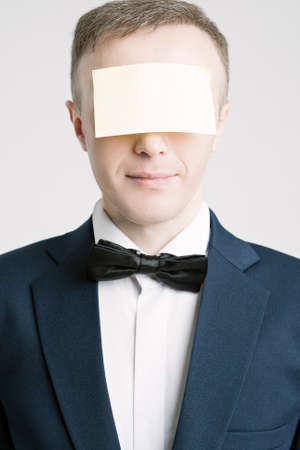 Business People Concepts And Ideas. Portrait of Caucasian Businessman With Paper Sticker on Forehead. Against White. Vertical Imageの写真素材