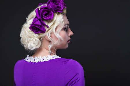 Fashion and Beauty Concepts. Portrait of Blond Caucasian Female With Purple Flowery Crown Posing Against Black.Horizontal Imageの写真素材