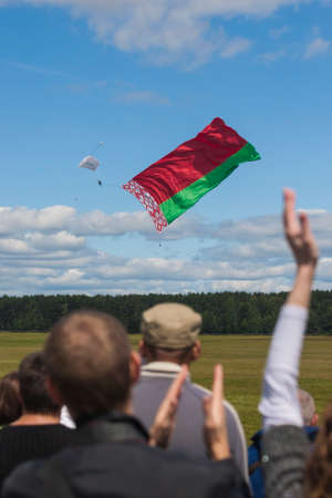 Minsk, Belarus-June 21, 2014: International ParachuterÃ¢ï¿½ï¿½s Team Performing in Air While Unwinding National Flag of the Republic of Belarus In Front of Spectators During Aviation Sport Event Dedicated to the 80th Anniversary of DOSAAF Foundation in Miのeditorial素材
