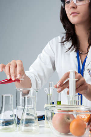 Portrait of Female Lab Staff Dealing With Flasks and Its Substances in Laboratory Environment. Vertical Image Orientationの写真素材