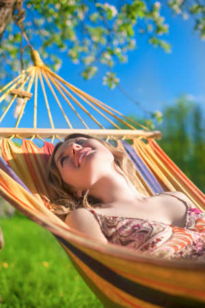 Portrait of Caucasian Blond Lady Resting in Hummock During Spring Time Outdoors.Vertical Image Compositionの写真素材