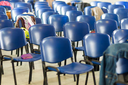 Closeup of Empty Chairs in Line with Workbooks Laid Upon It.Horizontal Shotの写真素材