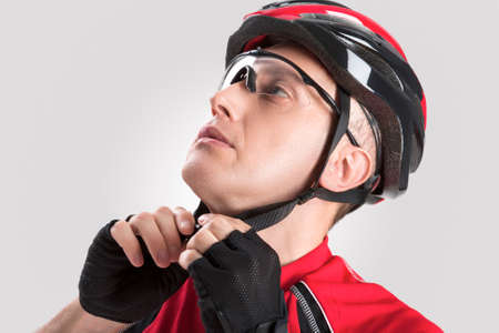 Cycling Safety Concept and Ideas. Portrait of Male Caucasian Cyclist Putting On Helmet. Against...
