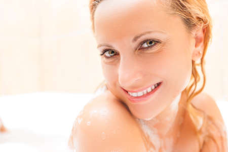 Face Closeup of Happy and Smiling Caucasian Blond woman Taking Bathtub. Positive Facial...