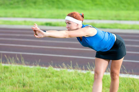 Young Red Haired Ginger Caucasian Female in Athletic Sportgear Making Arms Stretching  Excercises...