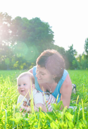 Happy Family Life Concepts and Ideas. Caucasian Brunette Mother with Her Toddler Son Spending Time Together Outdoors Embraced in Park. Vertical Imageの写真素材