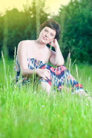 Portrait of Happy Smiling Caucasian Brunette Woman Posing Outdoors on Nature Background at Sunset. Vertical Imageの写真素材
