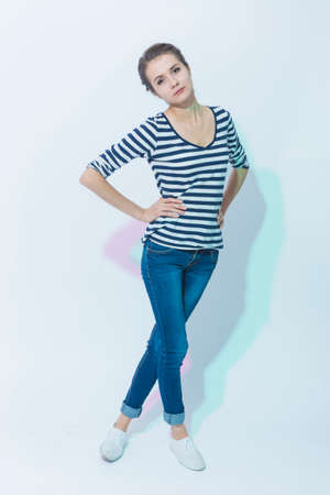 Slim Sensual Brunette Woman Posing Straight Against White Background. Color Filters Used. Vertical Image Compositionの写真素材