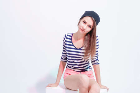 Youth Lifestyle and Fashion Concepts. Thinking Sensual Caucasian Brunette Girl Posing in Street Clothing Against White. Horizontal Image Compositionの写真素材