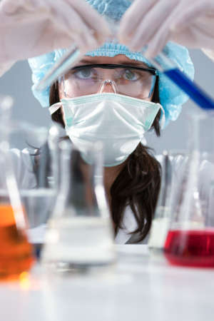 Researching and Science Concepts. Female Laboratory Staff in Facial Mask And Protective Gloves...
