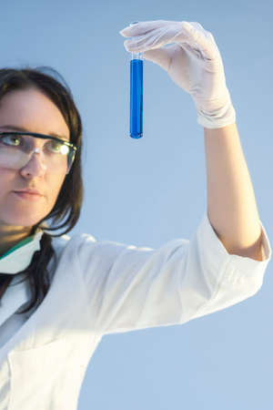 Female Laboratory Assistant Holding One Flask in Hand During Scientific Experiment. Vertical Image Compositionの写真素材