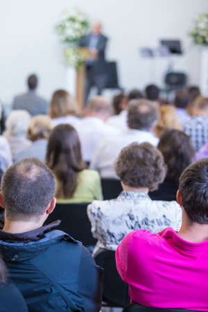 Group of Adult Professionals  Listening to the Lecturer Speaking on Stage During a Conference Indoors. Vertical Image Compositionの写真素材
