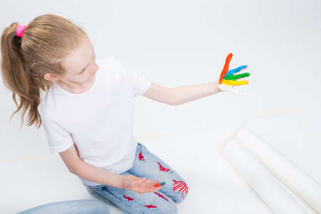 Kids Concepts. Portrait of Funny Young Girl With Brightly Painted Hands Doing Paint Craft. On white Background. Horizontal Image Compositionの写真素材