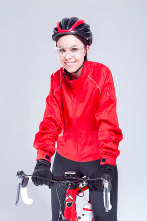 Cycling Ideas And Concepts. Portrait of Caucasian Female Cyclist Equipped in Cycling Outfit and Posing With Road Bike In Studio.Vertical Image Orientationの写真素材