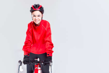 Cycling Ideas And Concepts. Portrait of Caucasian Female Cyclist Equipped in Cycling Outfit and Posing With Road Bike In Studio.Horizontal Image Compositionの写真素材