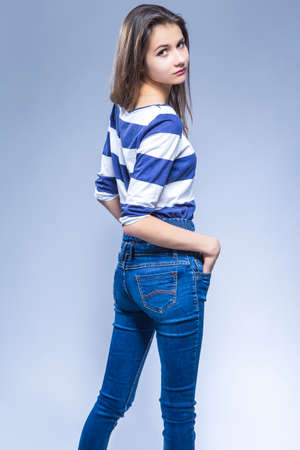 Youth Lifestyle  Concepts. Portrait of Sexy Posing Sensual Brunette Girl with Long Hair. Standing Turned Backwards With Shaped Body and Looking Throroughly At Viewer. Vertical Imageの写真素材