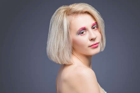 Beauty and fashion Ideas. Portrait of Caucasian Blond Female With Vivid Artistic Facial Makeup Against Gray. Horizontal Imageの写真素材