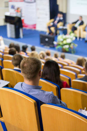 Business Conferences and People Concepts and Ideas. Group of People Attending Conference and Listening to the Host Speaker On Stage. Back View. Vertical Image Compositionの写真素材