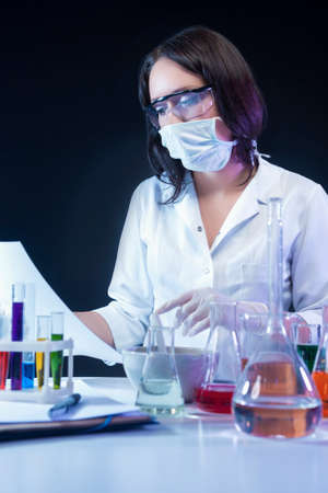 Medicine Concepts. Caucasian Female Laboratory Assistant Making a Mixture Using Glassware and...
