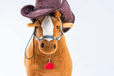 Children's Brown Plush Toy Horse With Natural Cowboy Stetson. Placed Against White Background. Horizontal Imageの写真素材