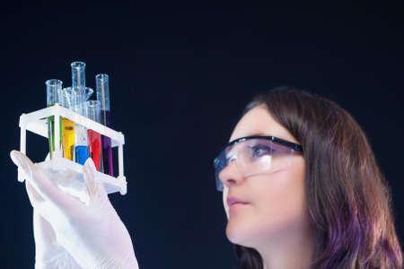 Medicine and Science Concepts. Caucasian Female Laboratory Assistant Examining Colorful Chemicals in Laboratory. Horizontal Image Compositionの写真素材
