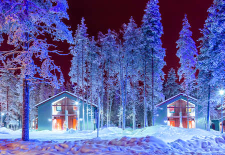 Travel Destinations Concepts. Traditional Nordic Suomi Houses Over the Polar Circle in Finland at Christmas Time. Located in Front of Amazing Winter Forest Scenery in Finland.Horizontal Shotの写真素材