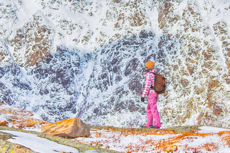 Mountain Destinations and Concepts. Young Woman With Backpack Travelling on Mountain Range at Lofoten Islands in Norway. Horizontal Image Compositionの写真素材
