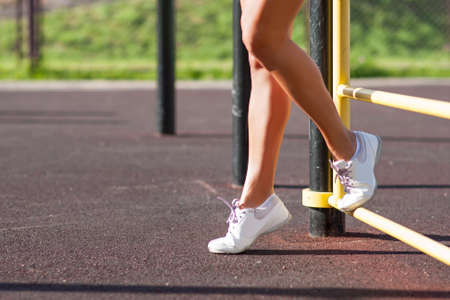Sport Concepts. Female Body Parts. Sexy Tanned Legs of Caucasian Female Athlete in Good Fit. Posing In Front of Trainer Outdoors.Horizontal Image Orientationの写真素材
