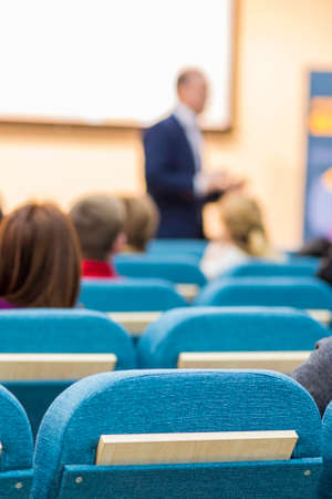 Business Meetings Concepts and Ideas. Mature Male Presenter Speaking in Front of a big Screen for The Group Of Listeneres During a Conference. Vertical Imageの写真素材