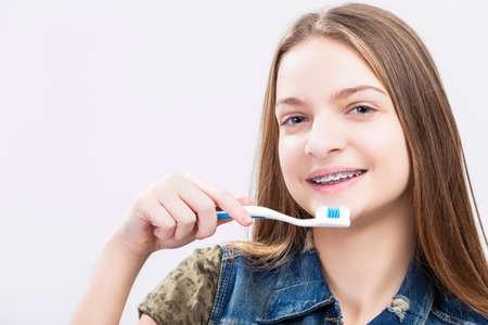 Dental Health Concepts. Portrait of Smiling Caucasian Teenage Girl with Teeth Brackets. Posing with Toothbrush.Horizontal Imageの写真素材