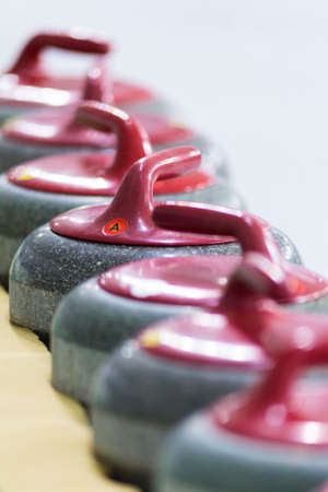 Sport Ideas and Concepts. Closeup of Curling Red Handle Stones on Ice.Vertical Shotの写真素材