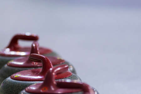 Sport Ideas and Concepts. Closeup of Curling Red Handle Stones on Ice.With Copy Space. Horizontal Image Orientationの写真素材