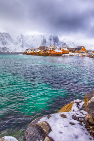Travel Concepts and Destinations. Group of  Traditional Yellow Norwegian Houses Located at Bay of Reine Village at Lofoten Islands in  Norway. Vertical Image Compositionの写真素材