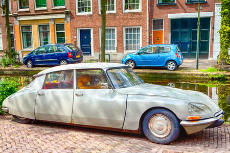 Travelling Through the Europe. Old Fashioned Retro Car in Front of Modern Cars on The Background in Small Dutch City Outdoor.Horizontal Imageのeditorial素材