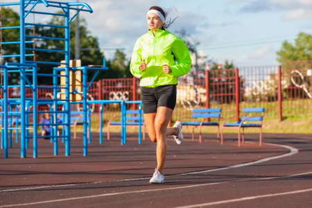 Jogging Concepts. Portrait of Professional Female Runner During Training. Running on Track and...