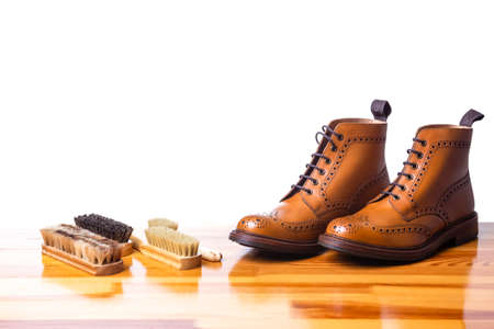 Mens Brogues Boots In Line With Cleaning Accessories on Shiny Table.Against White. Horizontal Imageの写真素材