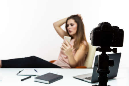 Blogger Concepts. Famous Cheerful Female Vlogger Filming Herself with Cellphone and DSLR camera. For...