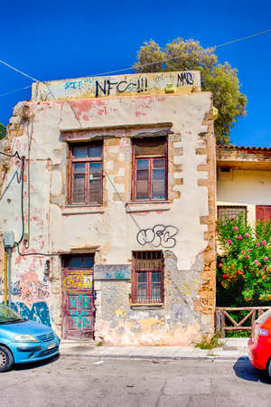 Chania, Crete - August 20, 2018: Two Colorful Cars Parked in Front of Old House with Grunge Textured Walls in Chania, in August 20, 2018のeditorial素材