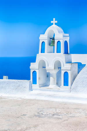Traditional White Flat Church With Bell and Cross in Oia Village in Santorini in Greece. Vertical Imageの写真素材