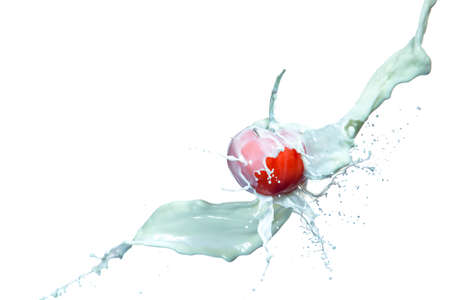 Milk Splashes and Droplets Falling Onto Fresh Red Tomato.Against White Background.Horizontal imageの写真素材
