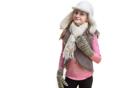 Winter Kids Fashion And Holidays Ideas. Smiling Caucasian Girl In Pink Vest and White Winter Hat, Scarf and Mittens. Over Pure White. Horizontal imageの写真素材